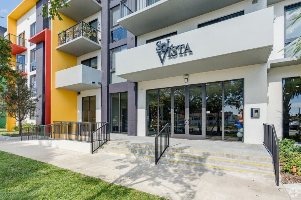 Entryway to Sol Vista. A small set of stairs leads up to a mostly glass doorway, leading into the apartment space.