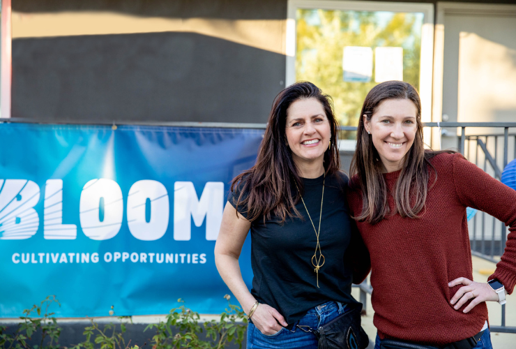 Carlee Chiate and Sydne Garchikin front of a BLOOM sign.